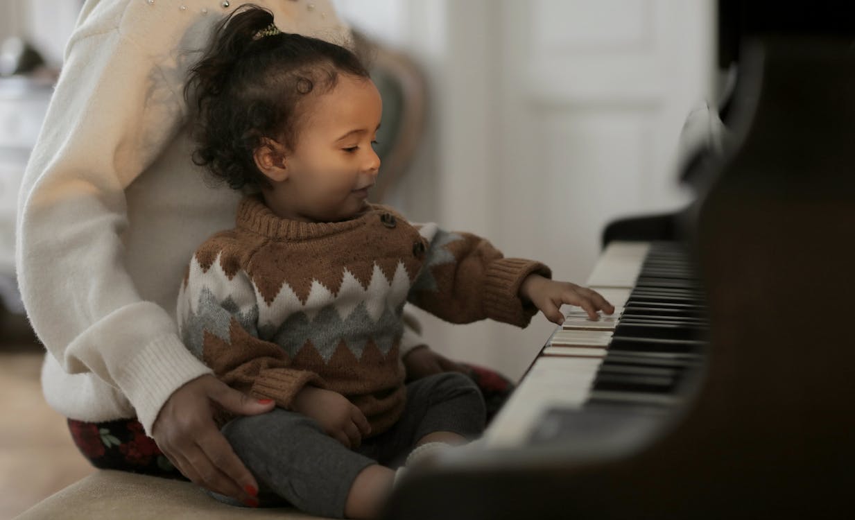 免費 彈鋼琴的棕色毛線衣的女孩 圖庫相片